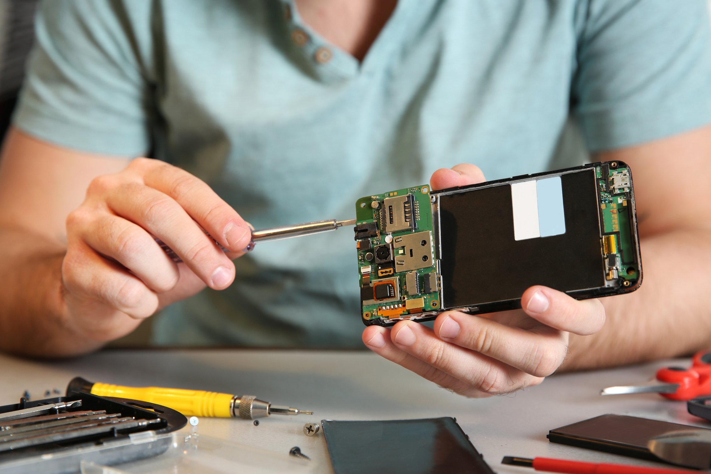 Technician Repairing Mobile Phone at Table, Closeup